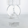 Der PHA Soft Peeling Cleanser gibt Gel aus einer durchsichtigen Flasche auf eine flache Oberfläche ab und unterstreicht so seine Peeling- und Feuchtigkeitsvorteile.