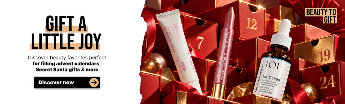 Schönheitsprodukte wie Lippenpflege, Lippenstiftstifte und Serum, angeordnet in roten Adventskalender-Schachteln.