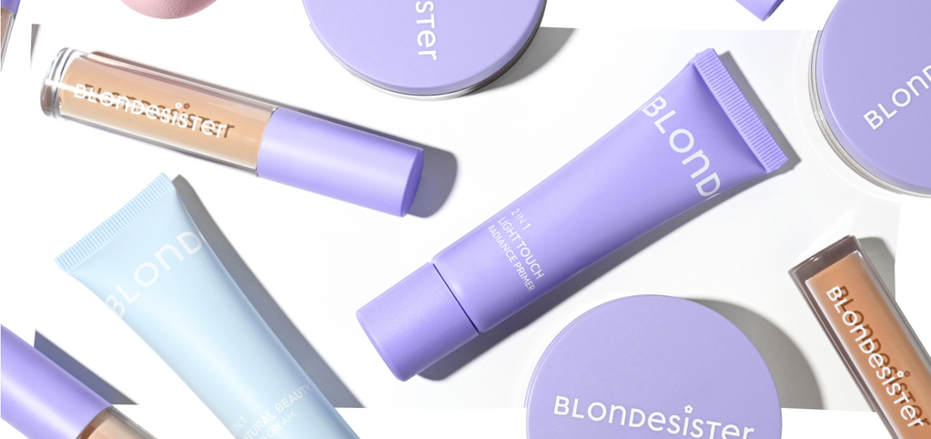 Verschiedene Make-up-Produkte von BLONDESISTER in pastellvioletten Verpackungen, angeordnet auf einem weißen Hintergrund.