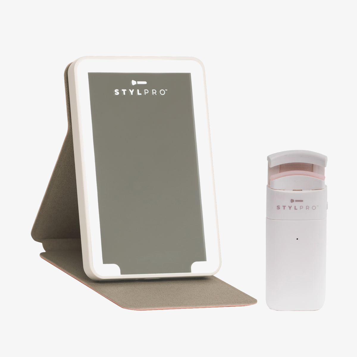 Der STYLPRO „Handy Little Travel Companion“ und ein beleuchteter Kosmetikspiegel auf einem Ständer sind gemeinsam abgebildet.