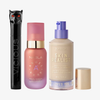 Drei NABLA-Produkte: schwarze Mascara mit Katzenkopf, rosa Angel Aura Serum-Primer und Skin Realist Tinted Balm in der Farbe 1 Fair mit lilafarbenem Pumpspender.