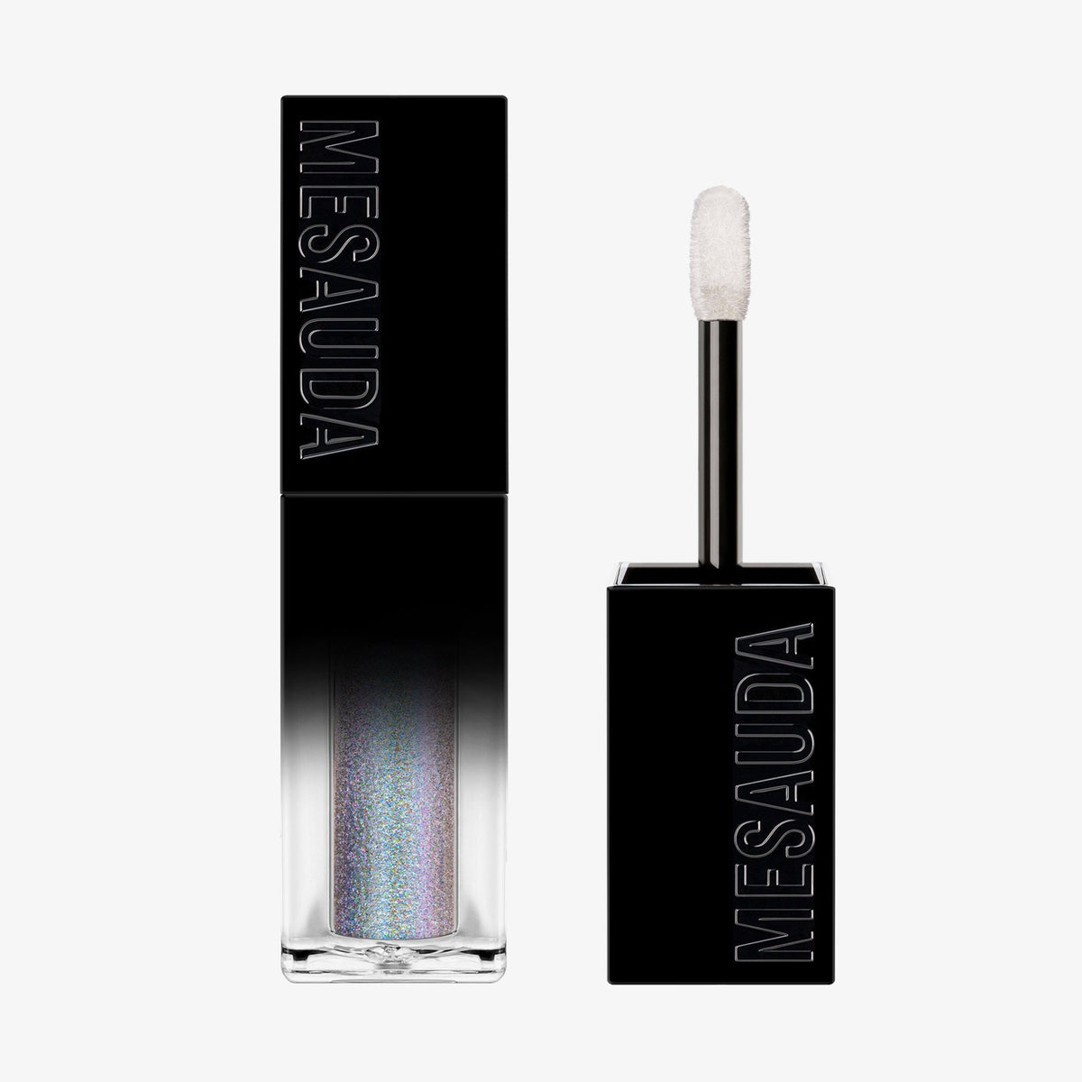 Der Galactic Shadow Flüssigliedschatten von Mesauda Beauty in einer rechteckigen Tube mit dem Deckel und Applikator daneben.

