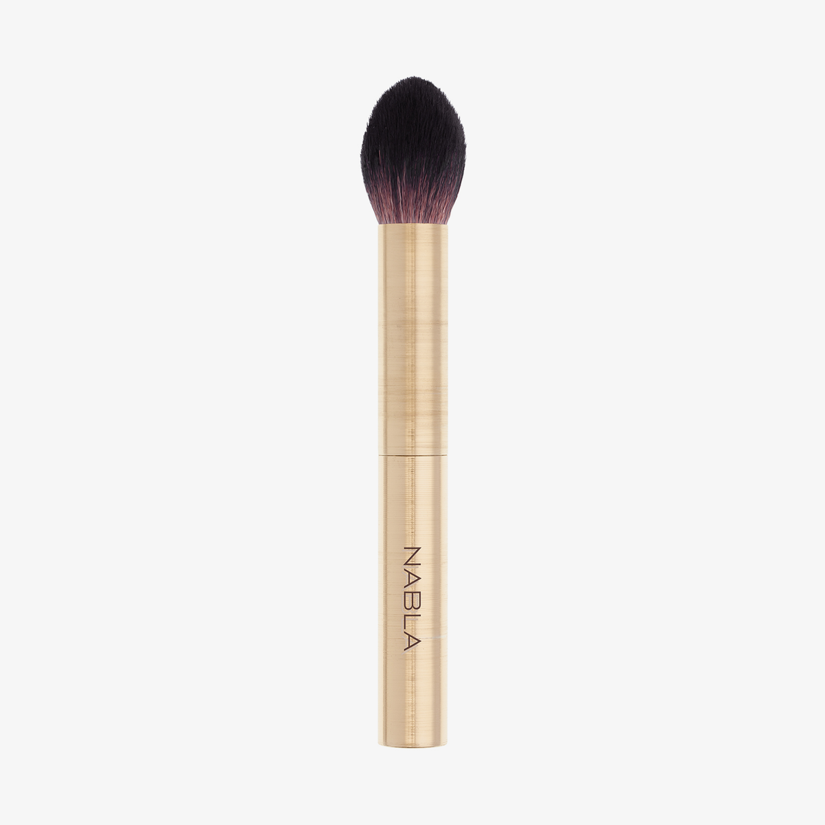 Der Cheek Shaper Brush verfügt über einen goldenen Griff, dunkle, spitz zulaufende Borsten und den Aufdruck NABLA auf dem Griff.