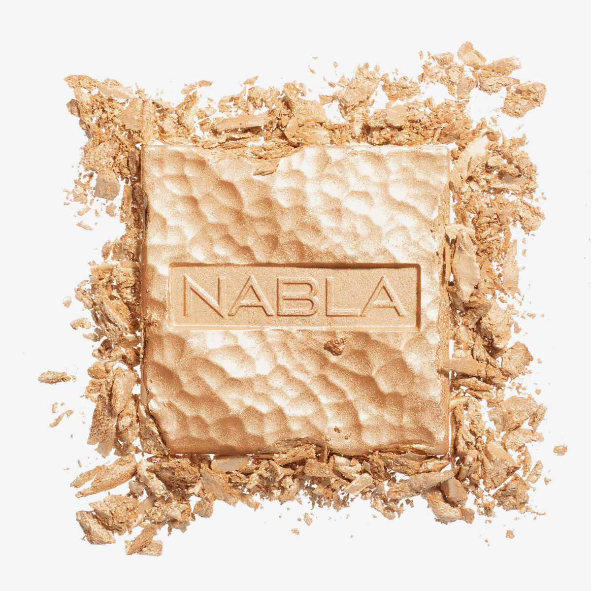 Ein quadratischer, goldener Skin Glazing-Presspuder mit der Prägung „NABLA“ auf der Oberseite, umgeben von zerstoßenen Stücken.