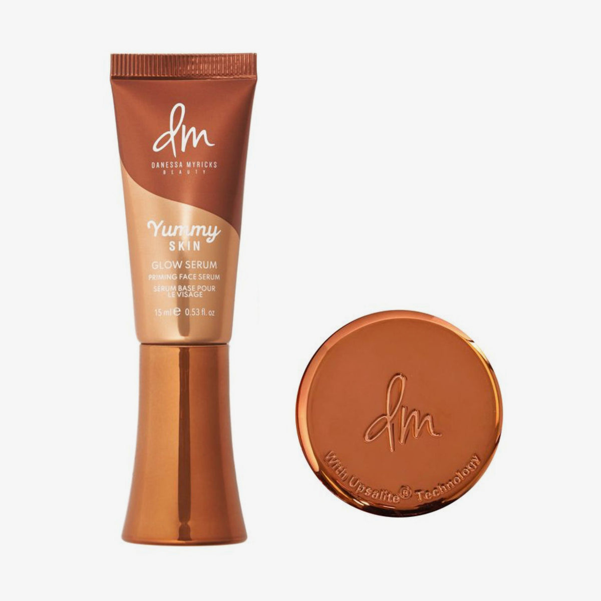 Eine Tube und ein rundes Kompaktpuder aus dem Danessa Myricks Yummy To Go Kit, beide in einer metallisch bronzefarbenen Verpackung.