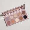 Die Essential Palette, ein offenes Lidschatten-Set mit zehn schimmernden und matten Tönen, wird auf einer hellen Oberfläche präsentiert.