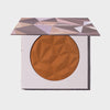 Eckige Kompaktdose mit geometrischem lilanem Muster und dunklem warmbraunen Puder des Infinity Bronzer Forever von LH Cosmetics vor weißem Hintergrund.