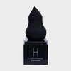 Auf einem schwarzen Ständer ist ein schwarzer Make-up-Schwamm „The Sponge“ von LH Cosmetics vor einem weißen Hintergrund abgebildet.