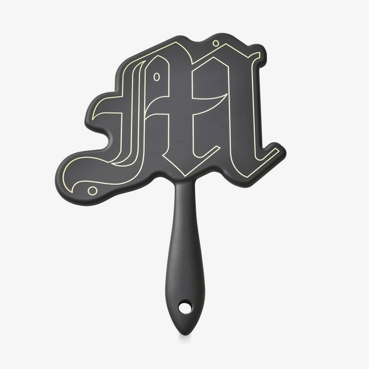 Der Made By Mitchell Mirror von Made by Mitchell ist ein Handspiegel mit einem Griff, der die Form des Buchstaben M mit goldenen Umrissen hat.