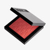 Das halb-geöffnete Rouge At First Blush von Mesauda Beauty in einer quadratischen Produktschale und eingeprägtem M-Muster.
