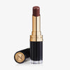 Ein geöffneter Beyond Jelly Lipstick in der Farbe ardor mit gold-schwarzem Gehäuse und separater Kappe mit NABLA-Prägung.