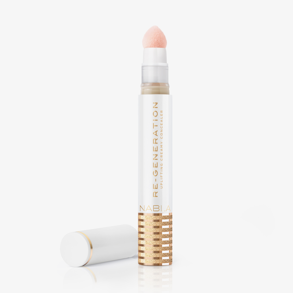  Eine weiß-goldene Tube Re-Generation Concealer in der Farbe Porcelain mit einer Schwammspitze und der daneben platzierten Kappe.