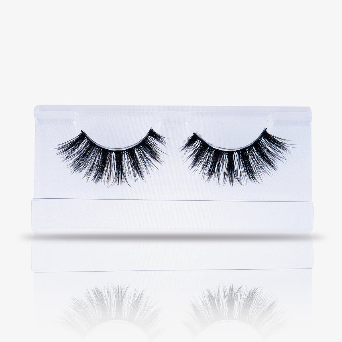 Ein Paar dramatische falsche Wimpern von NICLAY, elegant verpackt in einem durchsichtigen Plastiketui auf weißem Hintergrund.