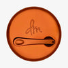 Runder geschlossener Behälter Yummy Skin Blurring Balm mit bronzefarbenem Deckel und kleinem Applikator.