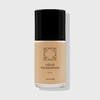 OFRA Liquid Foundation in der Nuance Bare in transparenter Glasflasche mit schwarzem Deckel und schwarzer Beschriftung, vor hellem Hintergrund.