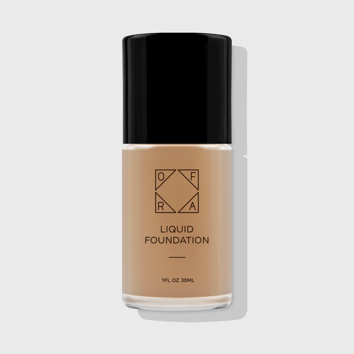 OFRA Liquid Foundation in der Nuance Autumn in transparenter Glasflasche mit schwarzem Deckel und schwarzer Beschriftung, vor hellem Hintergrund.