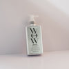 Eine silberne Flasche Dream Coat Supernatural Spray lehnt vor einem hellen Hintergrund.