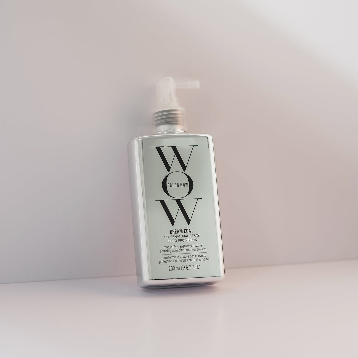 Eine silberne Flasche Dream Coat Supernatural Spray lehnt vor einem hellen Hintergrund.