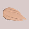 Ein Klecks Wide Awake Full Coverage Concealer Whipped Coffee in Hellbeige auf einem blassen Hintergrund.