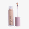 Auf weißem Hintergrund ist eine geöffnete Tube Wide Awake Full Coverage Concealer Whipped Coffee mit rosa Kappe und Applikatorstab abgebildet.