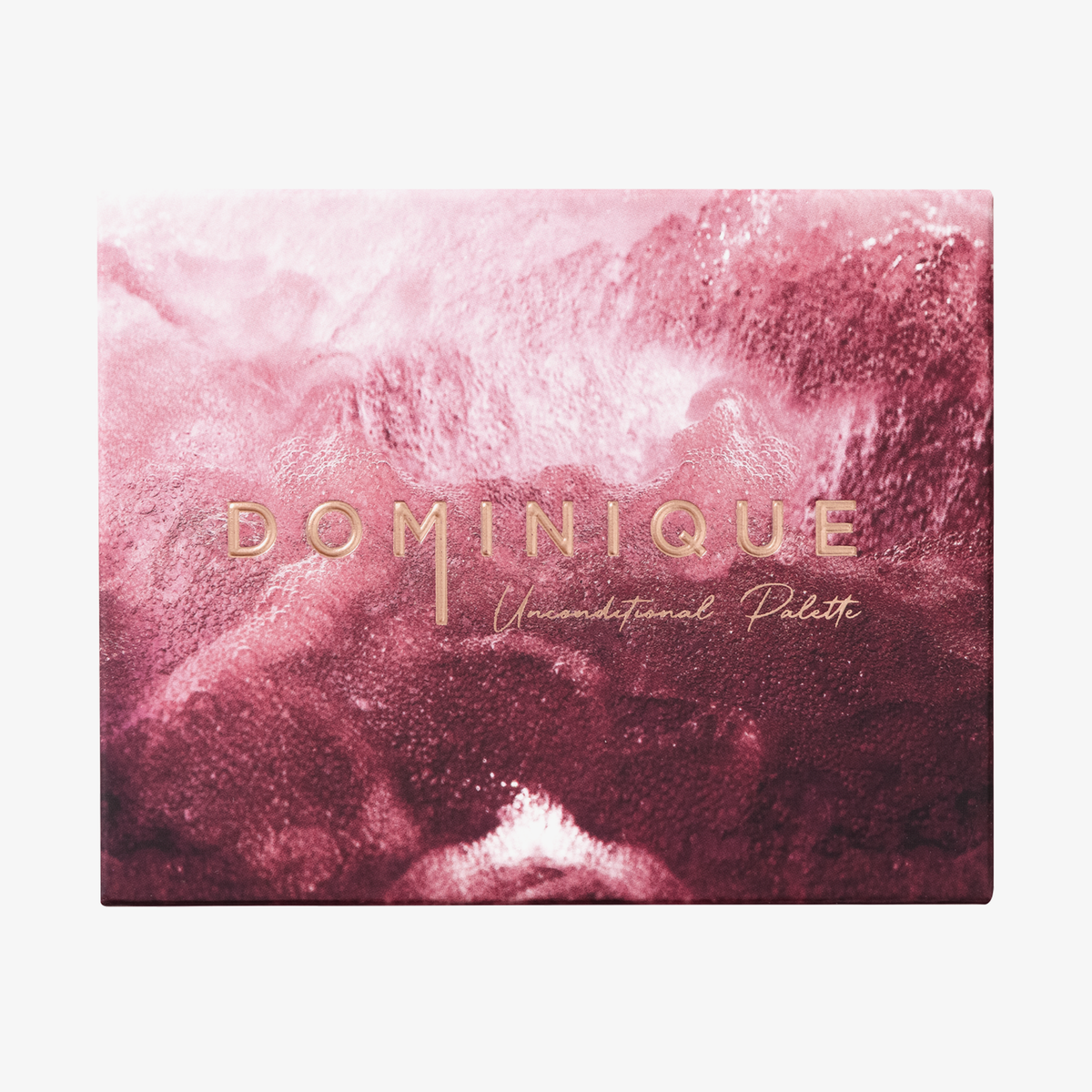Make-up-Box „Dominique Unconditional Palette“ in Pink und Burgunderrot mit goldener Schrift auf dem Deckel.