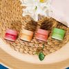 Vier farbenfrohe Tiegel der Laneige Lip Sleeping Mask EX auf einer gewebten Bastmatte platziert.