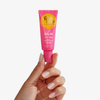 Eine Hand hält eine rosa Tube Lip Balm SPF 50+ Wild Strawberry von Bondi Sands vor weißem Hintergrund