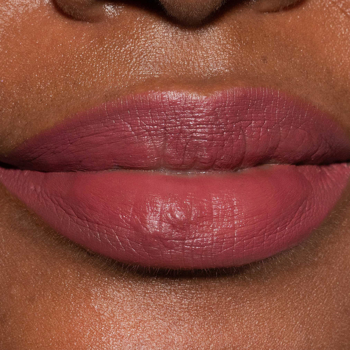 Nahaufnahme der Lippen einer Frau mit dunklem Teint, die den Crayon Lipliner Nugget von LH Cosmetics trägt.