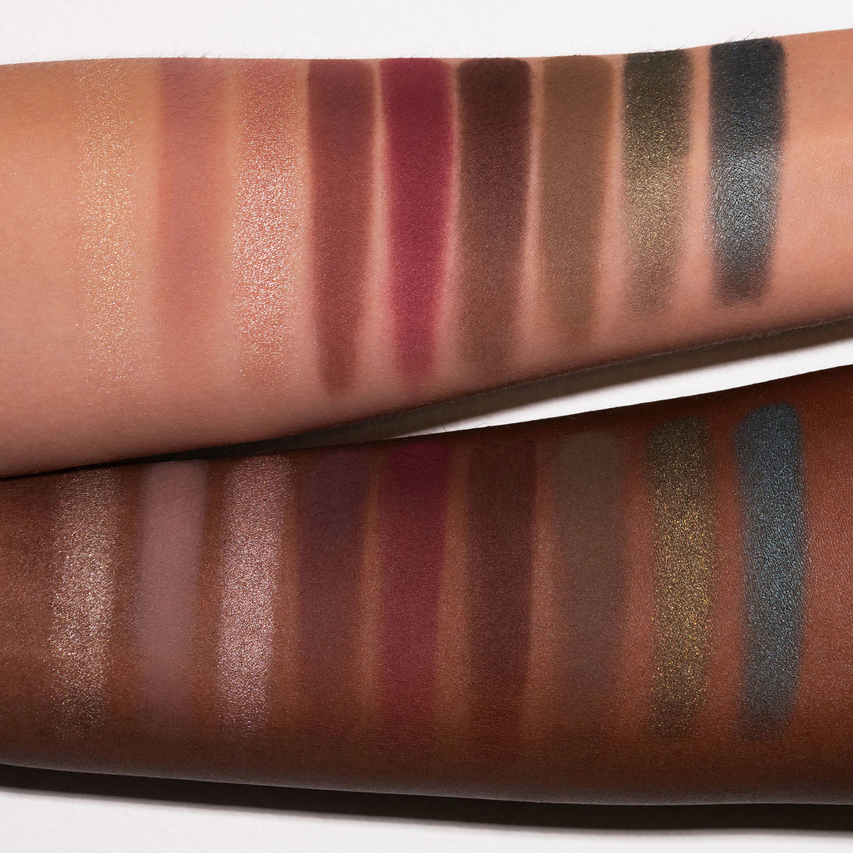 Zwei Arme in unterschiedlichen Hauttönen mit schimmernden und matten Farbtönen aus der LH Cosmetics Reload Palette.