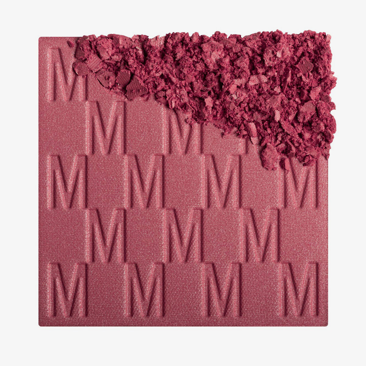 Das Rouge At First Blush von Mesauda Beauty mit eingeprägtem M-Muster, die obere, rechte Ecke ist in losem Puder zerkleinert dargestellt.
