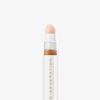 Nahaufnahme der weiß-goldenen Tube Re-Generation Concealer in der Farbe Amber mit rosafarbener Schwammspitze – für tiefe Haut mit golden-warmem Unterton.