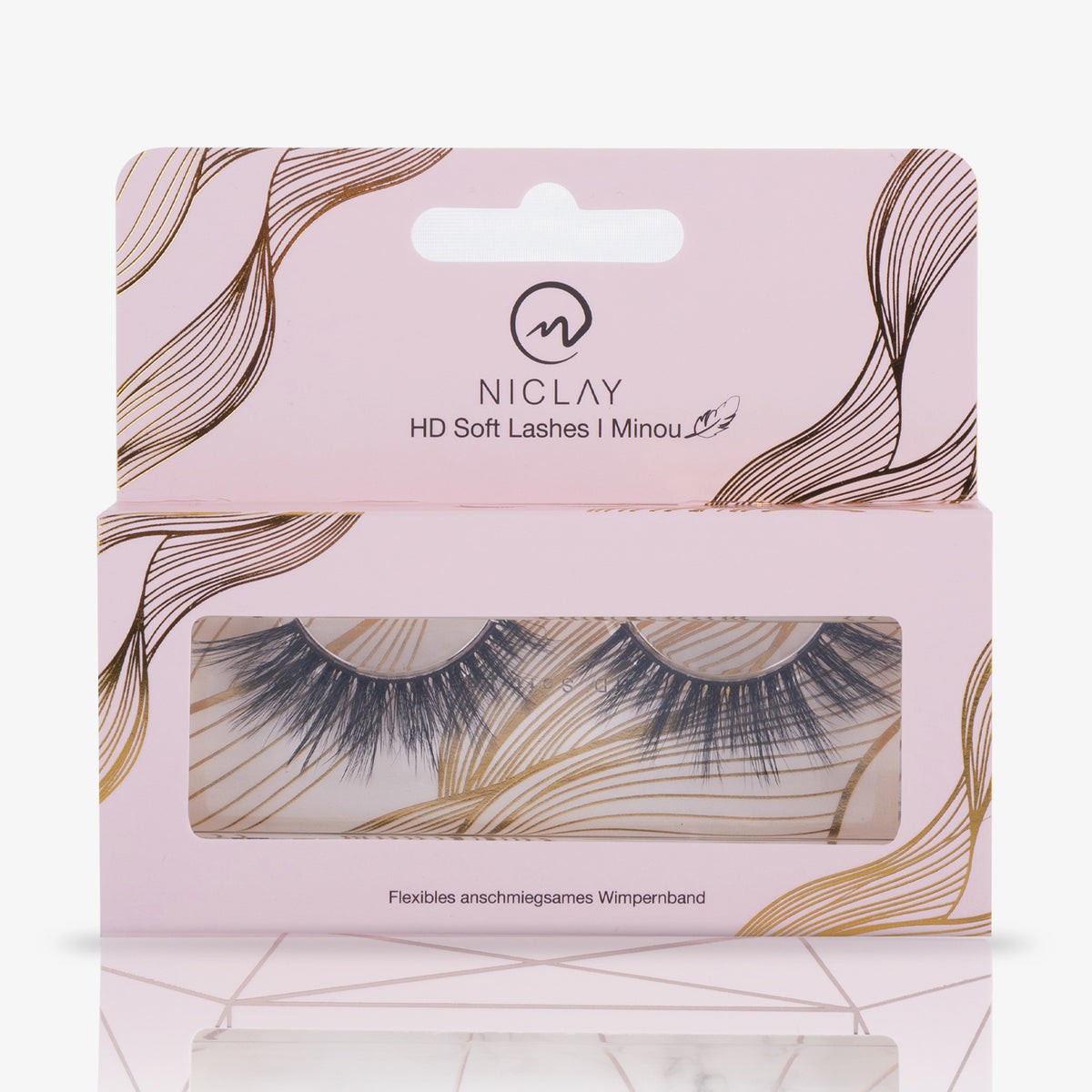 NICLAY HD Soft Lashes in einer rosafarbenen Box mit abstrakten Linien in Gold und Schwarz, wobei die Minou Wimpern durch ein Fenster sichtbar sind.