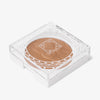 Quadratisches, durchsichtiges Kompaktpuder mit OFRA Cosmetics Pure Glow Finishing Powder und OFRA-Logo auf dem Deckel.