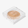Das OFRA Cosmetics Pure Glow Finishing Powder in einem kompakten, durchsichtigen Kunststoffbehälter mit einem geometrischen Design .