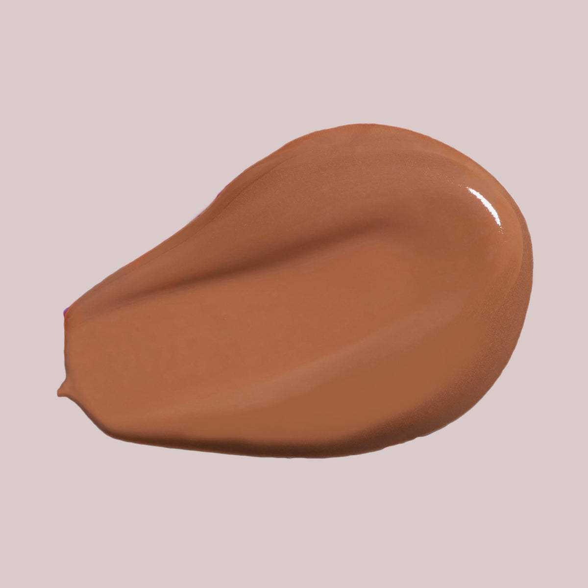 Ein glatter Farbstreifen des Wide Awake Full Coverage Concealer in einem mittelbraunen Farbton auf hellbeigem Hintergrund.