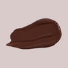 Ein Klecks Wide Awake Full Coverage Concealer Espresso Coffee in Dunkelbraun auf einem blassen Hintergrund.