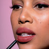 Eine Frau trägt den Crayon Lipliner in Cherry von LH Cosmetics auf ihre Lippen auf.