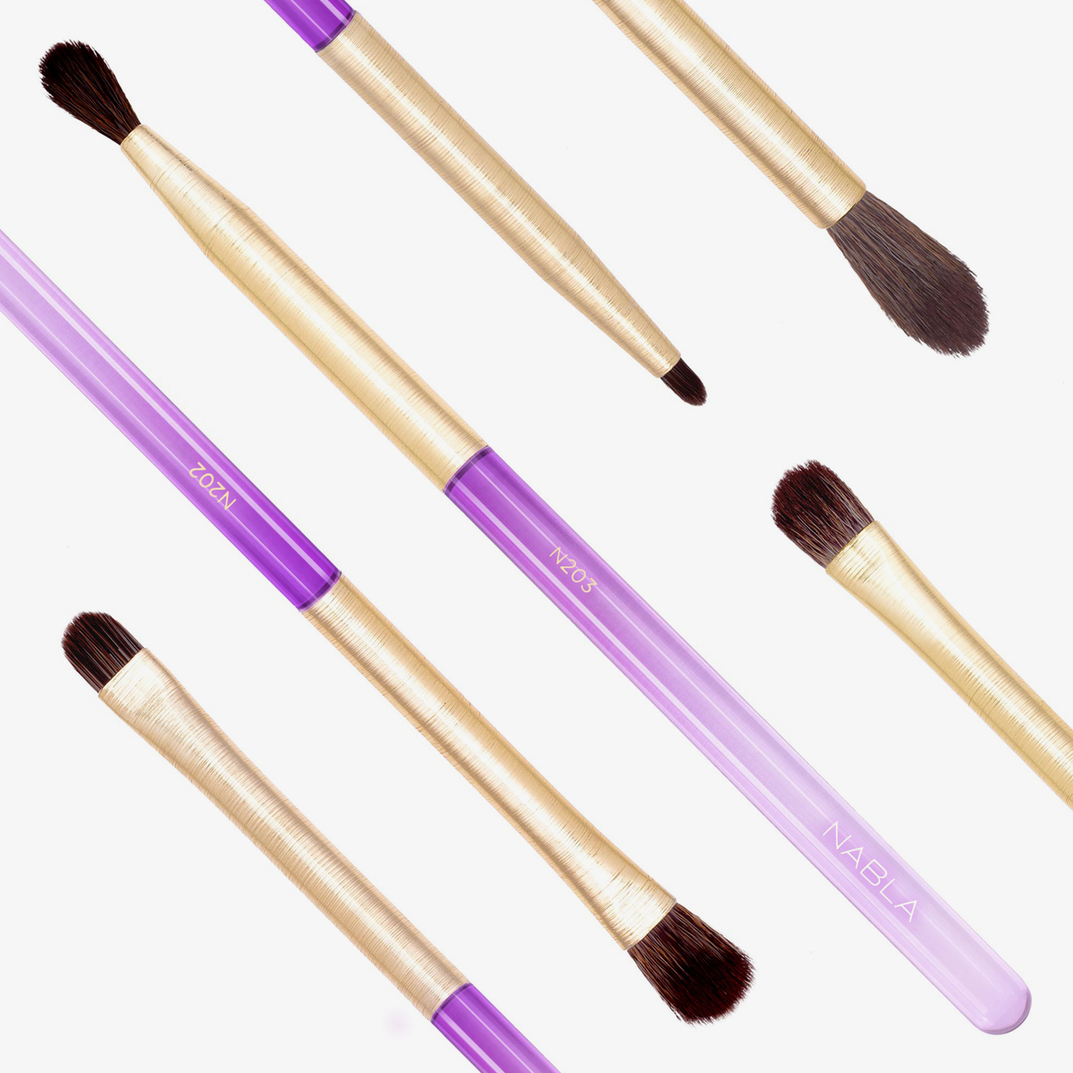 Das Amethyst Detail Brush Set mit goldenen Griffen und violetten Akzenten ist diagonal auf einem weißen Hintergrund angeordnet.