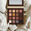 Die Side By Side Nude-Palette mit 16 offenen Lidschattentönen ist von weißen, geformten Händen umgeben.