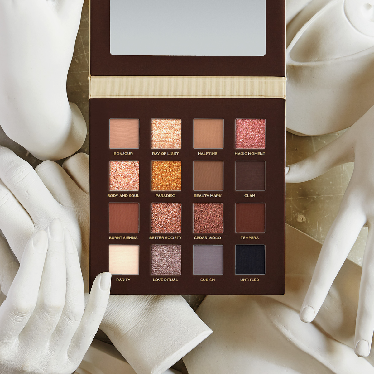 Die Side By Side Nude-Palette mit 16 offenen Lidschattentönen ist von weißen, geformten Händen umgeben.