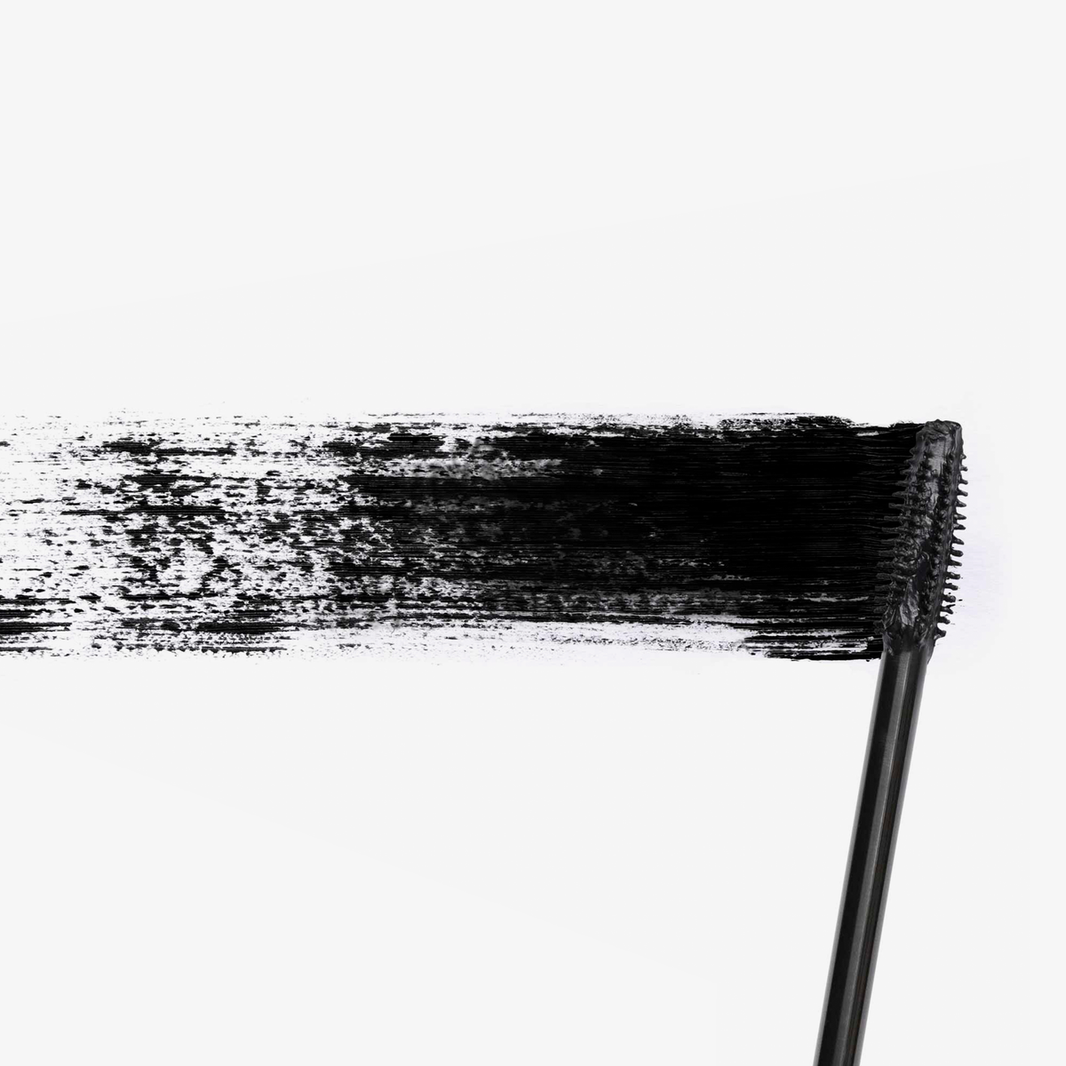 Eine Vicious™ Mascara-Bürste verteilt einen dicken, schwarzen Streifen Mascara auf einem weißen Hintergrund.