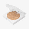 Nahaufnahme des offenen OFRA Pure Glow Finishing Powders in Medium, das feine, schimmernde Puder mit Wellenstruktur zeigt.