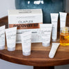 Das Olaplex Discovery Kit mit acht Mini-Haarpflegeprodukten wird auf einem Holztisch präsentiert.