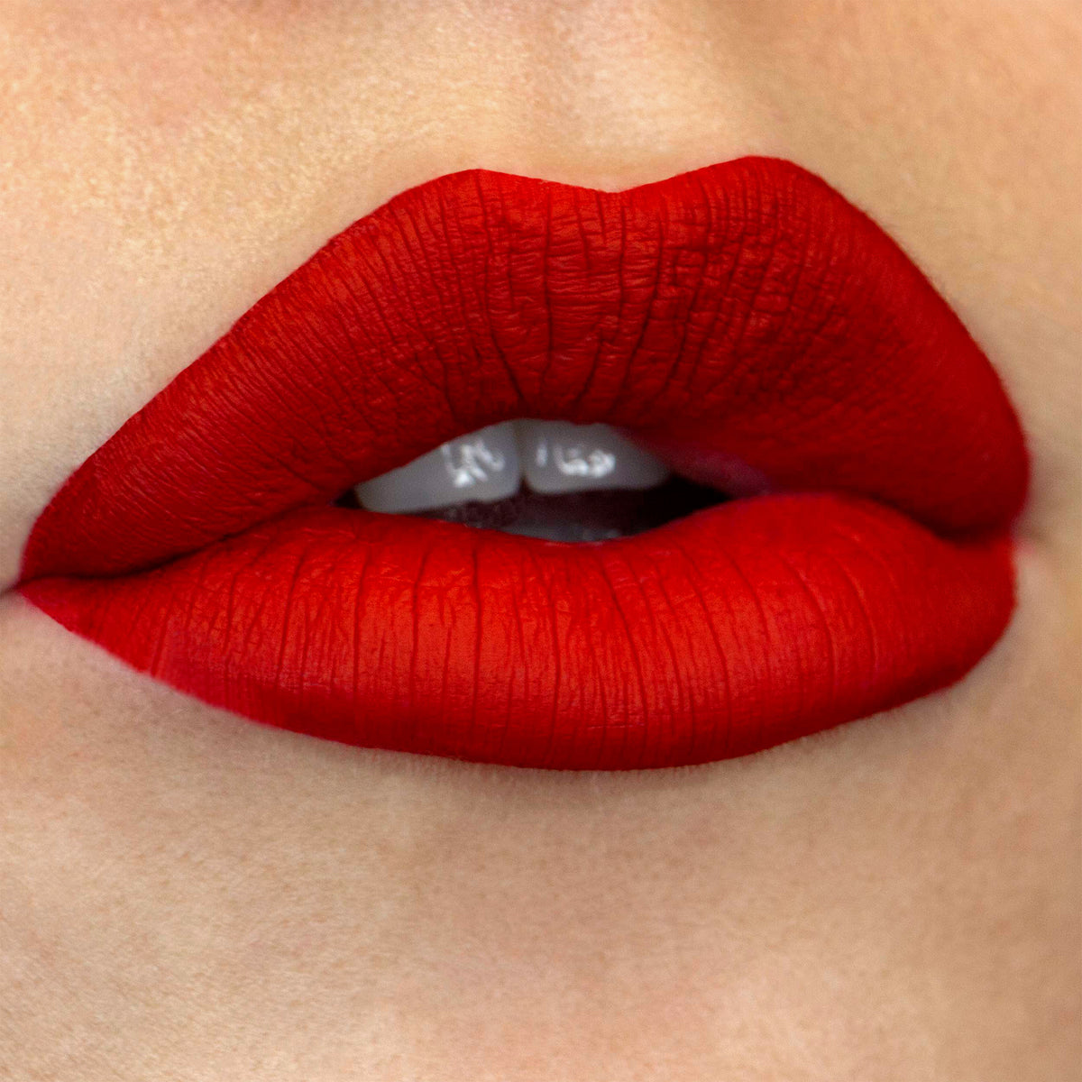 Nahaufnahme von perfekt geschminkten Lippen in sattem, mattem Rot für ein intensives, deckendes Finish.