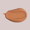 Ein Klecks Wide Awake Full Coverage Concealer Caramel in Warmbraun auf einem blassen Hintergrund.