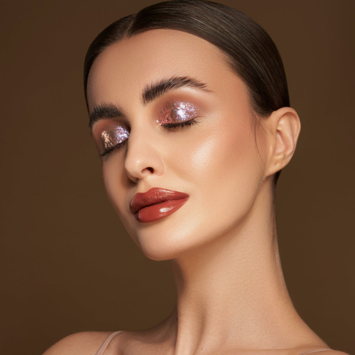 Person mit geschlossenen Augen und hellem Hautton präsentiert schimmernden, irisierenden Make-up-Look mit den Infinite Chrome Flakes.
