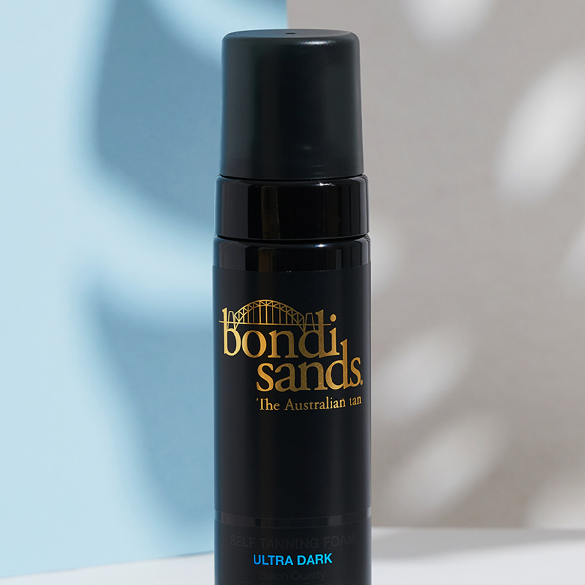 Eine Flasche Bondi Sands Self Tanning Foam Ultra Dark vor einem schattigen Hintergrund