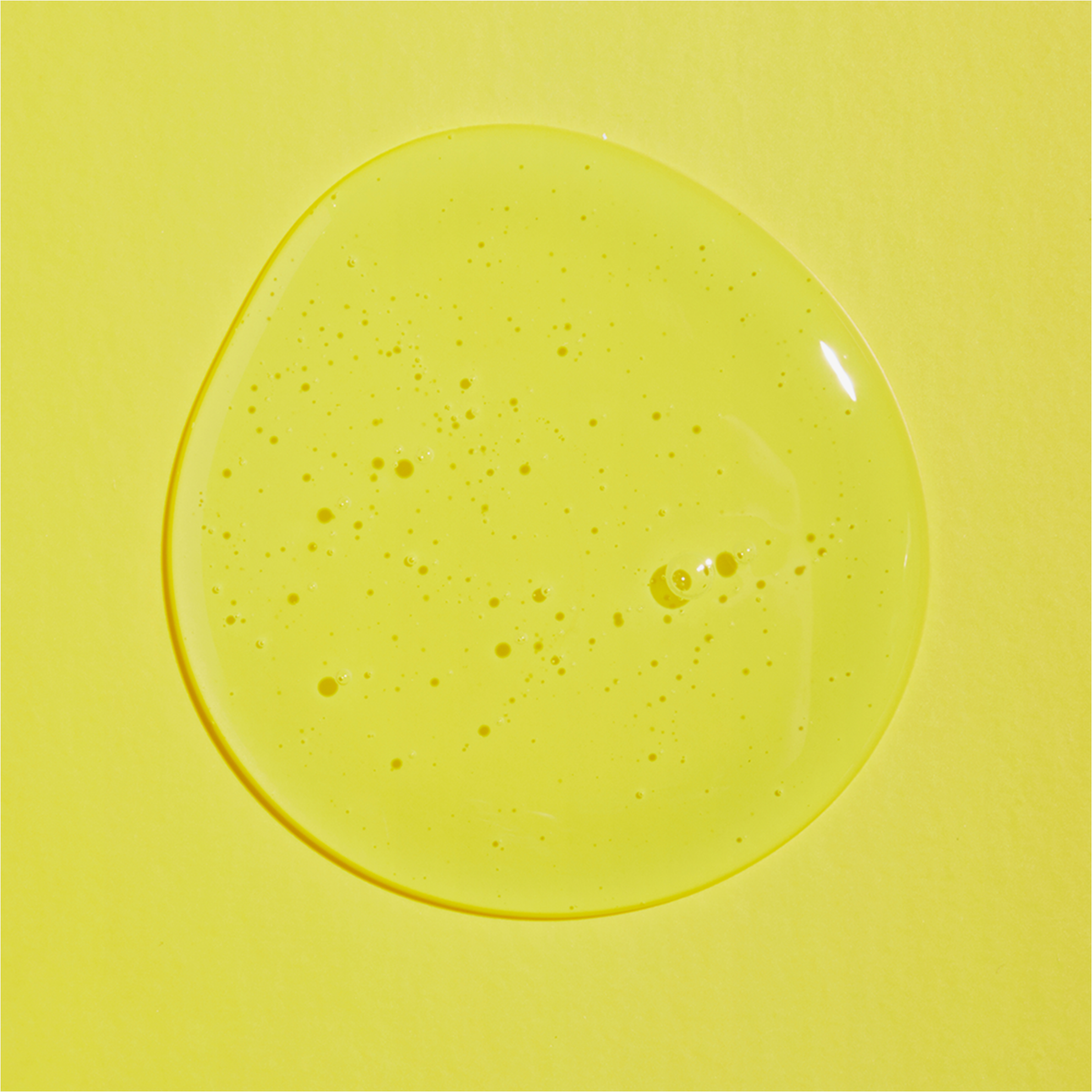 Ein transparenter Klecks des Low-pH Good Morning Gel Cleanser auf einer leuchtend gelben Oberfläche.