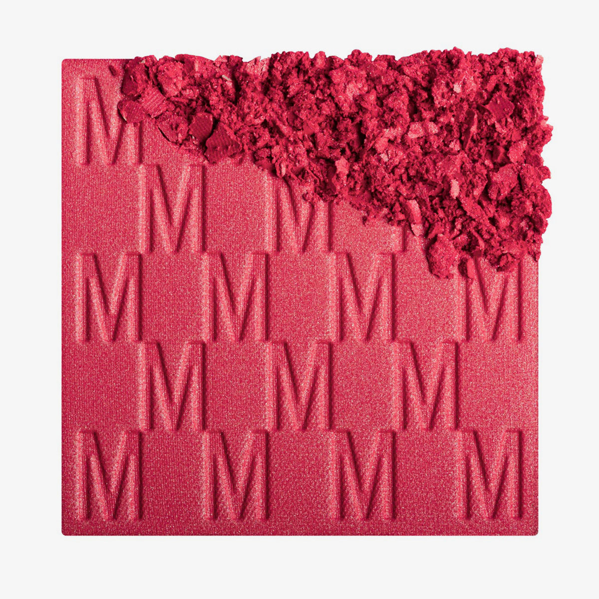 Das Rouge At First Blush von Mesauda Beauty mit eingeprägtem M-Muster, die obere, rechte Ecke ist in losem Puder zerkleinert dargestellt.
