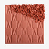 Das Rouge At First Blush von Mesauda Beauty mit eingeprägtem M-Muster, die obere, rechte Ecke ist in losem Puder zerkleinert dargestellt.
